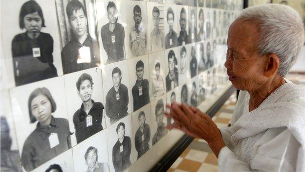 Woman looks at pictures of Cambodians killed during Khmer Rouge rule in the former Tuol Sleng Prison in Phnom Penh