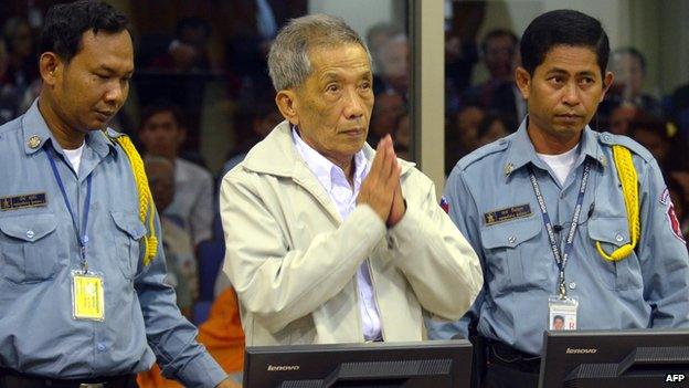 Fomer Khmer Rouge prison chief Kaing Guek Eav - better known as Duch (c) - greets judges at Cambodia's UN-backed war crimes court in Phnom Penh on February 2012.