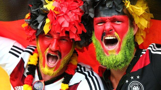 Two Germany fans wearing face paint celebrate victory against Brazil