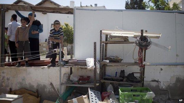 Residents of Netivot look at the damage caused by a Palestinian missile strike, 10 July