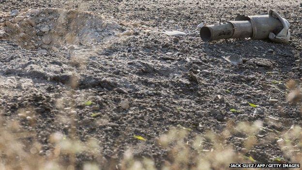 The remains of a rocket fired by Palestinian militants from the Gaza Strip lie on a road along the southern Israeli border with the Palestinian enclave on 10 July 2014.