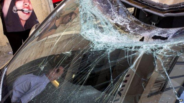 Israelis looks at a car damaged by remnants of a long-range rocket fired by Palestinians militants from Gaza after being shot down by Israel's "Iron Dome" in Tel Aviv, Israel, on 10 July 2014