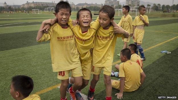 Young Chinese football players help an injured player off the field during training at the Evergrande International Football School on 12 June, 2014 near Qingyuan in Guangdong Province, China