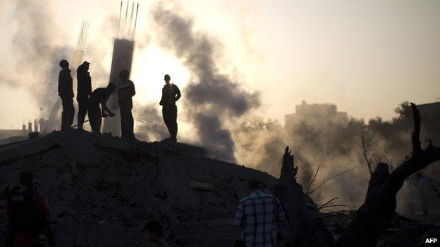 Palestinian men inspect the site of an Israeli military strike in Gaza City on 8 July 2014 .