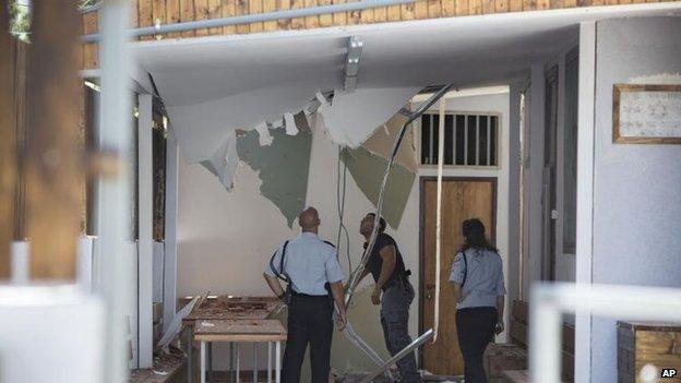 Israeli police check damage from a rocket on a synagogue in Tel Aviv, 11 July