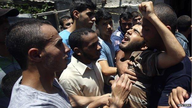 A relative of eight Palestinian members from al-Haj family, who medics said were killed in an air strike that destroyed at least two homes, mourns during their funeral in Khan Younis in the southern Gaza Strip on 10 July 2014