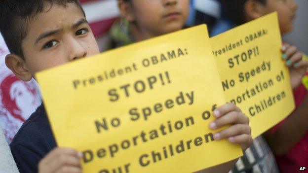 A child holds up a sign telling President Obama not to deport children detained at the US southern border.