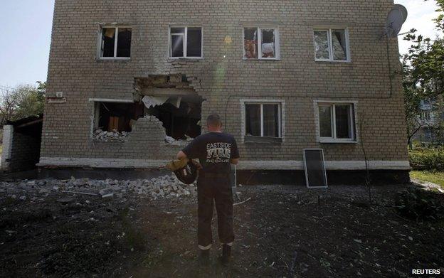 A rescue worker outside a damaged block of flats in Marinka, Donetsk, 12 July