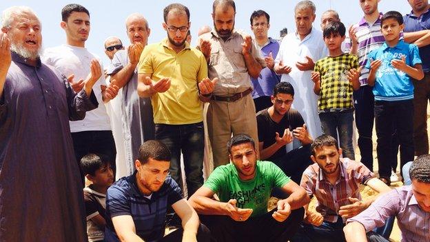 Family praying during burial of Suha Abu Sa'adah one of two disabled Palestinian women killed in Gaza in an Israeli air strike, 12 July 2014.