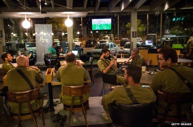 Israeli soldiers watch the World Cup Final in a cafe in Sderot, 13 July