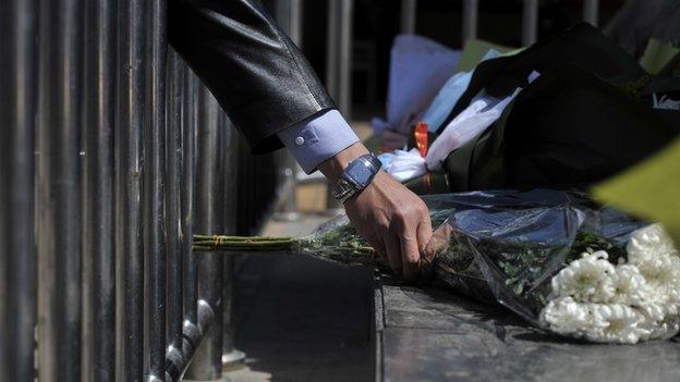 A man lays a wreath on the square outside the railway station in Kunming, southwest China's Yunnan province on 2 March, 2014