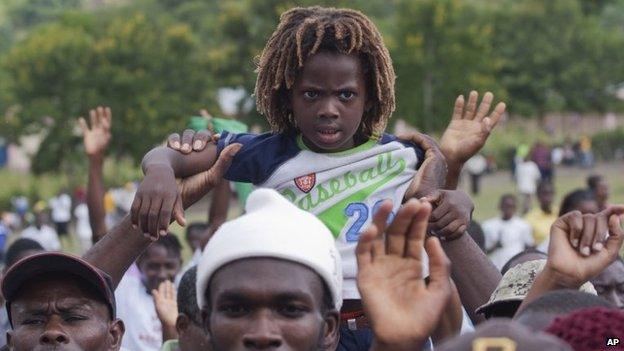 A young boy is held up by his father as Ban Ki-moon speaks during the launch of sanitation campaign in Hinche, on 14 July, 2014