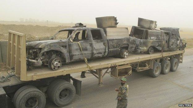 Burned-out vehicles are transported by the Iraqi military in Salahuddin province (15 July 2014)