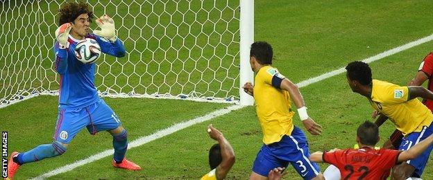 Mexico goalkeeper Guillermo Ochoa saves a header from Brazil's Thiago Silva