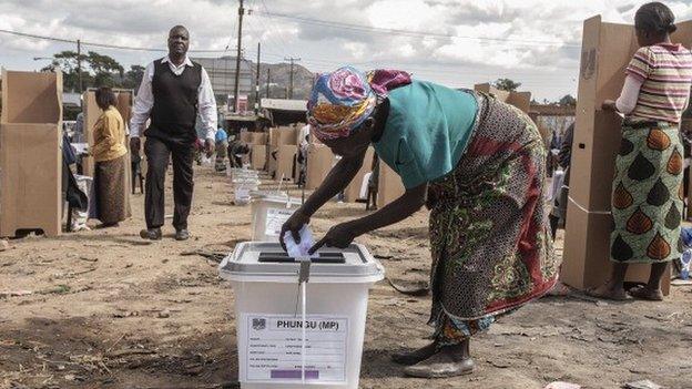 A Malawian woman casts her ballot as voting procedures resume on 21 May 2014 in Blantyre, Malawi
