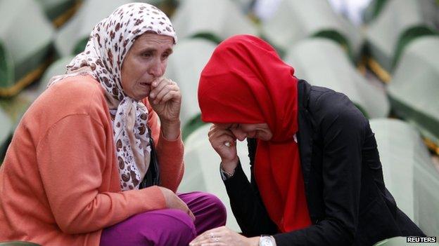 Bosnian Muslim women alongside the coffin of a relative, one of the 175 coffins of newly identified victims from the 1995 Srebrenica massacre, in Potocari Memorial Centre near Srebrenica (14 July 2014)