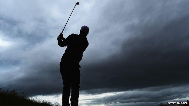 Silhouette of golfer Justin Rose swinging his club