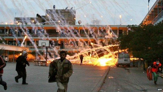 Palestinians run during an Israeli strike at a UN school in Beit Lahiya, northern Gaza, on 17 January 2009