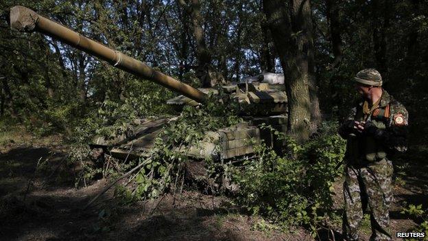 A pro-Russian separatist stands guard near a T-64 tank in Donetsk, eastern Ukraine (16 July 2014)