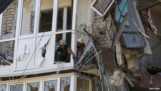 Rescuers work at a shattered five-storey building which was damaged by a recent shelling in the eastern Ukrainian town of Sloviansk (16 July 2014)