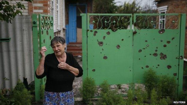 A woman cries near her house, which was damaged by a recent shelling, in the eastern Ukrainian village of Semenovka, near Sloviansk (15 July 2014)