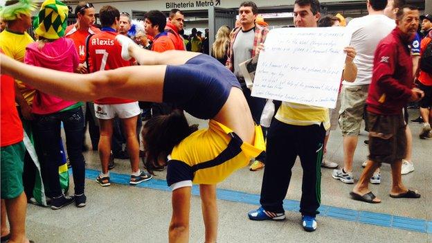 A gymnast attempts to raise money from football fans in Sao Paulo to compete at Rio 2016