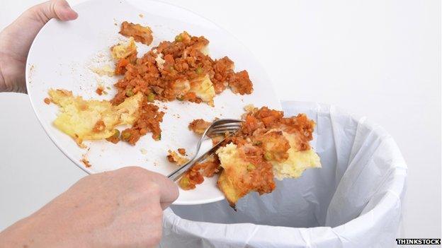 Food being scraped into a bin