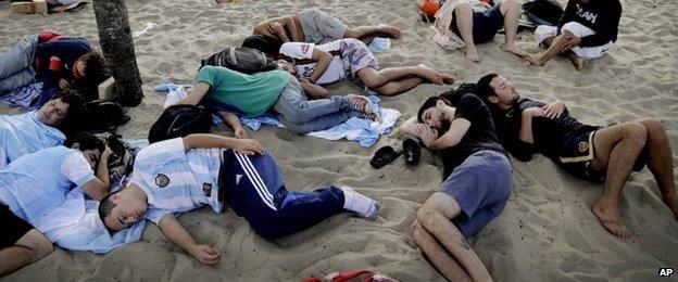 Fans sleep on Copacabana beach, 15 June 2014