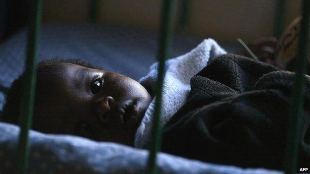 A young HIV-positive orphan lies in his cot at the Nyumbani Children's Home in Nairobi, Kenya - 2005