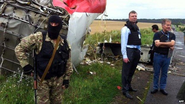 OSCE monitors (right) reach the crash site, escorted by rebels, 18 July