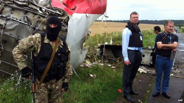 OSCE monitors (right) and a pro-Russian gunman at the crash site. Photo: 19 July 2014