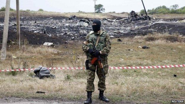 A pro-Russian separatist stands at the crash site of Malaysia Airlines Flight MH17, near Grabovo in eastern Ukraine, 19 July 2014