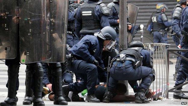 French riot police officers bring a man down on the ground near the aerial metro station of Barbes-Rochechouart, in Paris, 19 July 2014