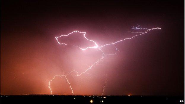 Lightning strikes over a town at night