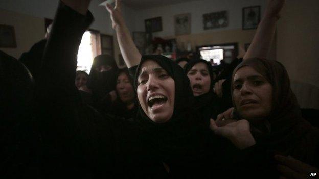 Palestinian relatives of Roshdi Naser mourn during his funeral in the Khan Younis refugee camp in the southern Gaza Strip, 19 July 2014