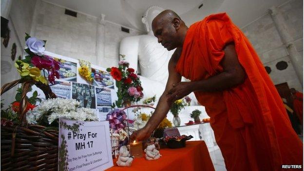 A monk performs a prayer during a special vigil for victims of the downed Malaysia Airlines Flight MH17, inside a Buddhist temple in Kuala Lumpur July 20, 2014