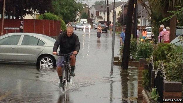 A man rides a bike through flood water