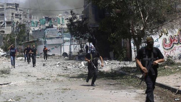 Fighters from the ruling Hamas movement run during an ongoing Israeli military offensive on the Shejaiya neighbourhood between Gaza City and the Israeli border, 20 July 2014