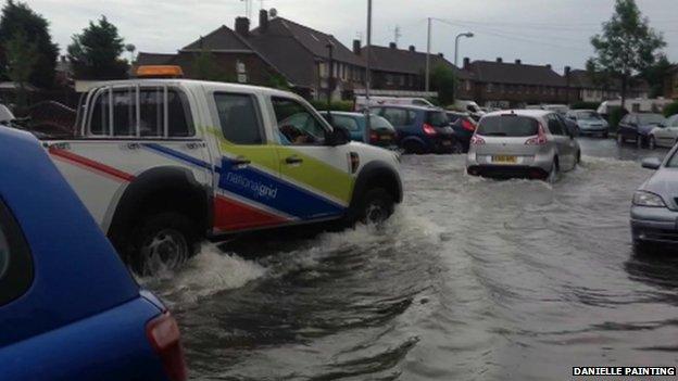 Cars moving through flooded road in Canvey Island