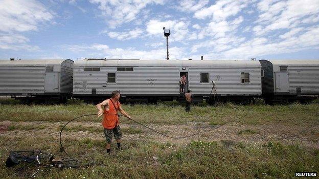 Railway employees work near refrigerator wagons in Torez carrying the bodies of victims of the plane crash - 20 July 2014