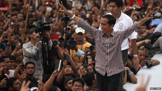 Indonesian presidential candidate Joko Widodo gestures to his supporters after delivering a speech at Gelora Bung Karno stadium in Jakarta on 5 July, 2014