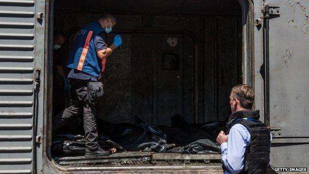 Dutch investigators and OSCE monitors examine the bodies in Torez. Photo: 21 July 2014