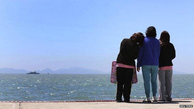 Relatives of passengers who died when the Sewol ferry sank look out to the sea at the port in Jindo - 30 April 2014