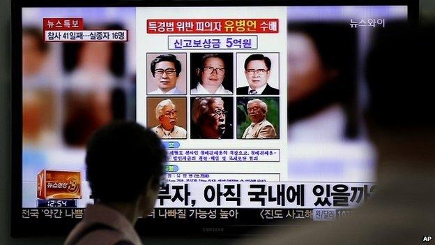 A woman looks at a 'wanted' poster for Yoo Byung-eun, shown on a South Korean TV news channel - 26 May 2014