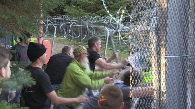 protesters pushing the fence