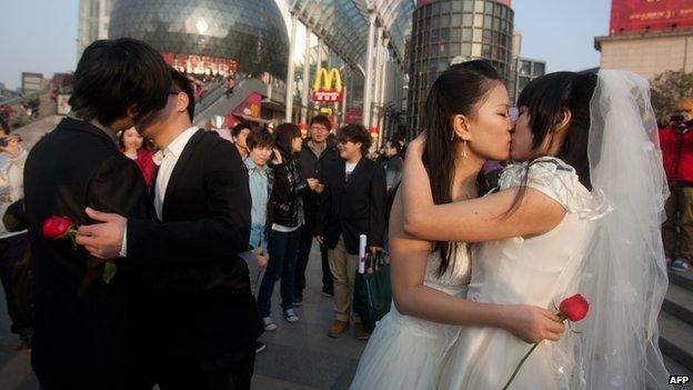 In a picture taken on 8 March, 2011 gay couples kiss during their ceremonial 'wedding' as they try to raise awareness of the issue of homosexual marriage, in Wuhan, in central China's Hubei province