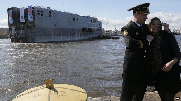 Stern of Mistral warship in St Petersburg and Russian naval officer with girlfriend