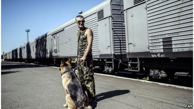 Armed rebel guarding train with bodies