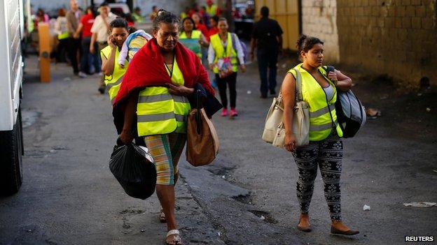 Residents of the Tower of David leave the building in Caracas, 22 July 2014
