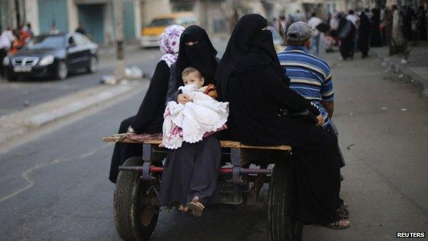 Palestinians ride in a donkey cart as they flee their houses following heavy Israeli shelling during an Israeli ground offensive east of Khan Younis in the southern Gaza Strip, 23 July 2014